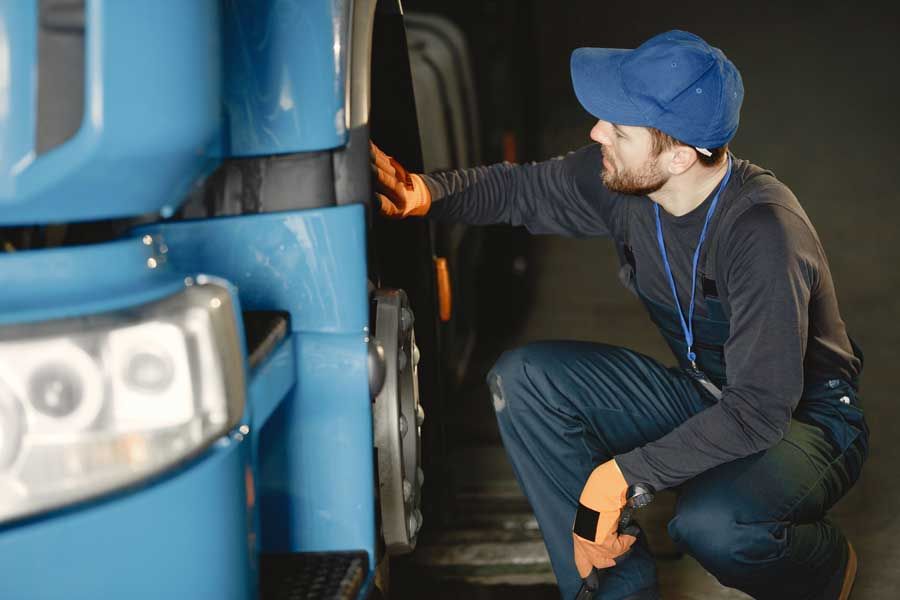 A truck mechanic inspects the truck tires of a fleet vehicle.