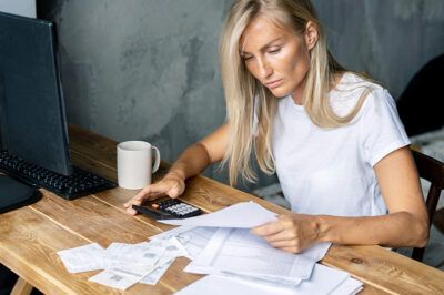 Small business owner calculating expenses and reviewing receipts