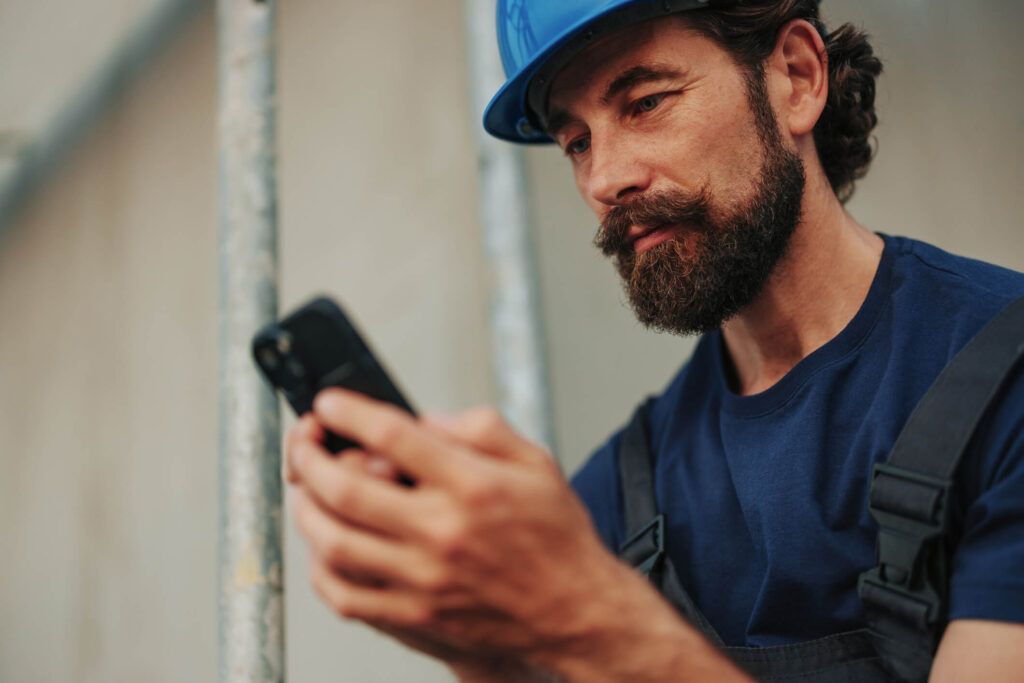 A construction company owner wearing a hard hat is able to view his workers’ fuel purchases right from his phone.