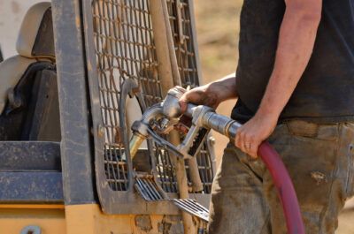 A fleet driver fuels his construction vehicle on a residential construction site.